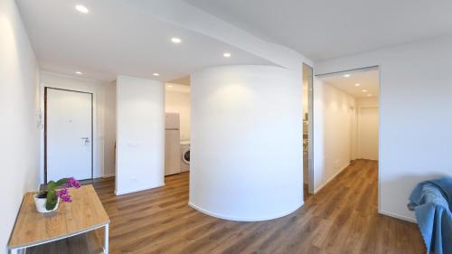 a living room with a table and a white wall at Blu - La Casa sul Mare in Lido di Ostia