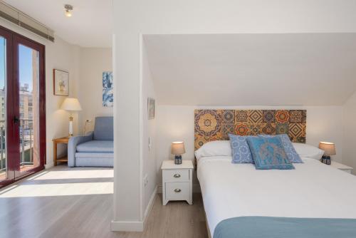 een slaapkamer met een wit bed en een blauwe stoel bij OLD TOWN - Cultural Experience in Málaga
