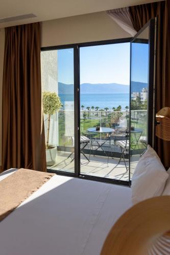 a bedroom with a bed and a view of the ocean at Mahoro Boutique Hotel in Vlorë