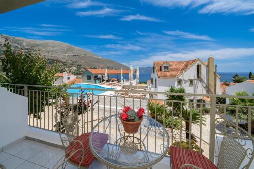 a balcony with a table and chairs and the ocean at MAKIS VILLAGE-APARTMENTS in Ayia Evfimia