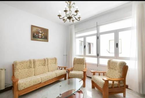 a living room with a couch and two chairs and a chandelier at Apartamento Delfina in Ondárroa