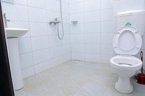 a bathroom with a toilet and a sink at Primland Hotel Buyala in Buloba