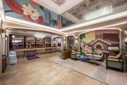 a lobby with a mural of flowers on the walls at Mercure Nantong Suxitong Riverside in Nantong