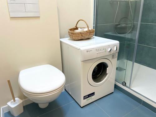 une salle de bain avec machine à laver et toilettes dans l'établissement ღ Les Lauriers Roses - Calme, Terrasse & Parking, à Saint-Médard-dʼAunis