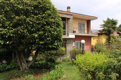 una casa con un árbol delante en old new LUGANO, en Lavena Ponte Tresa