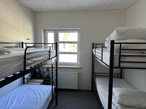 a room with three bunk beds and a window at Mololo Art Hostel in Sopot