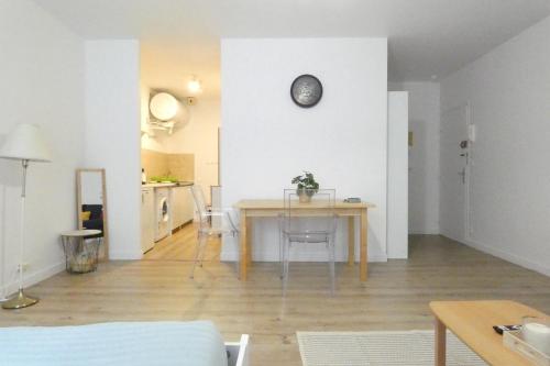 - un salon avec une table et une horloge murale dans l'établissement Marechal Joffre Central near train station, à Nantes