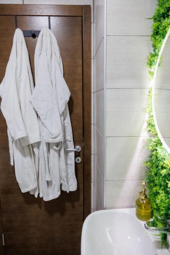 a bathroom with white towels hanging on a door at Harmonia Lux Aqua park in Jagodina