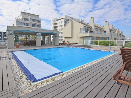 a swimming pool on the deck of a building at Cape Town Beachfront Accommodation in Blouberg in Bloubergstrand