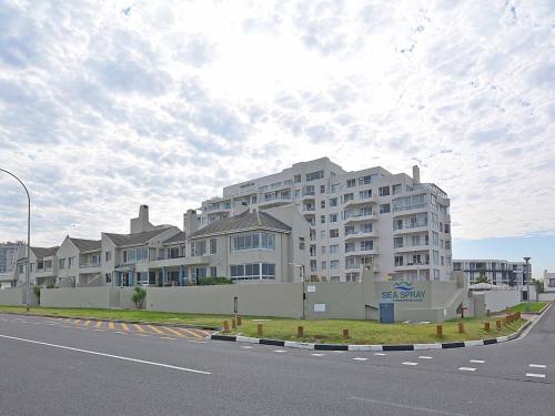 a large apartment building on the side of a street at Cape Town Beachfront Accommodation in Blouberg in Bloubergstrand
