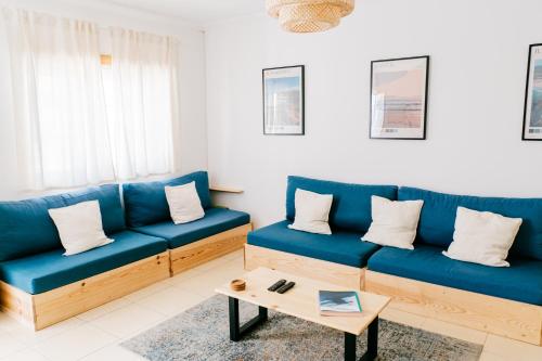 a living room with blue couches and a coffee table at Green House in Baleal