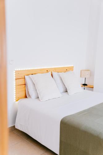 a bedroom with a bed with white sheets and pillows at Green House in Baleal