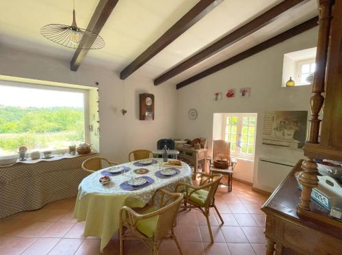 une salle à manger avec une table et une cuisine dans l'établissement Nature, calme et confort - Bienvenue à Maymac, à Pampelonne