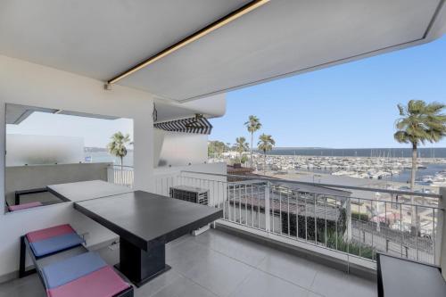 un balcon avec une table et des chaises et une vue sur un port dans l'établissement F2 Palm Beach - Pointe Croisette, à Cannes