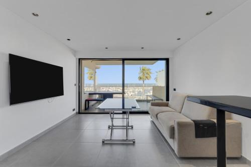 un salon avec un canapé et une télévision dans l'établissement F2 Palm Beach - Pointe Croisette, à Cannes