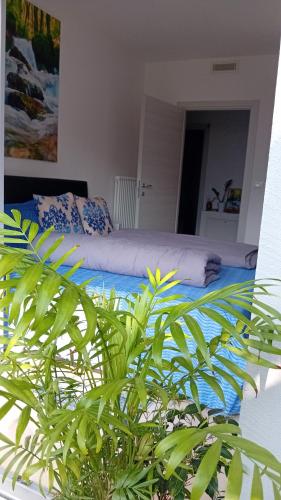 a bedroom with a bed and a green plant at Appartment Lodged Mamma Maria in Mattarello