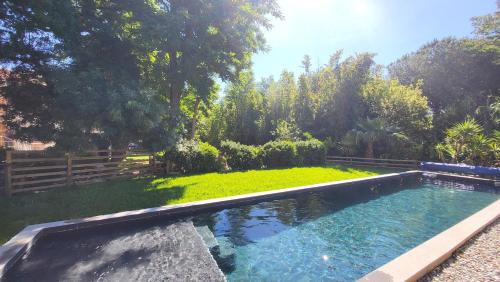 - une piscine dans une cour avec un jardin dans l'établissement BAMBOU SERENITE ECO LOGIS -Piscine, à Elne