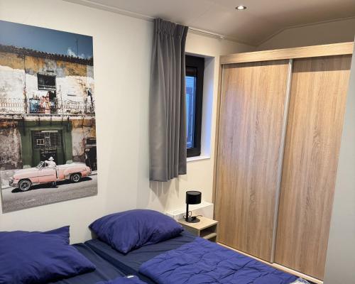 a bedroom with a bed and a pink car on the wall at Enkhuizer Strand Chalet Meereszauber Nr 304 in Enkhuizen