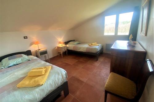 une chambre avec un lit et un bureau et un lit sidx sidx sidx dans l'établissement La Grange d'Anthounin, à Redortiers