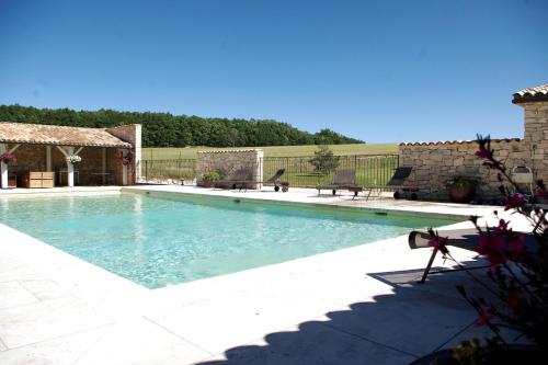 - une piscine dans une cour avec 2 chaises dans l'établissement La Grange d'Anthounin, à Redortiers