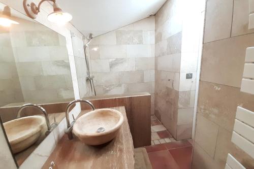 La salle de bains est pourvue d'un lavabo en bois et d'une baignoire. dans l'établissement La Grange d'Anthounin, à Redortiers