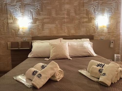 łóżko z 3 poduszkami na górze w obiekcie Casa Vacanze Fiore di Loto w mieście Leporano