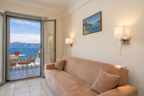 a living room with a couch and a view of the ocean at MAKIS VILLAGE-APARTMENTS in Ayia Evfimia