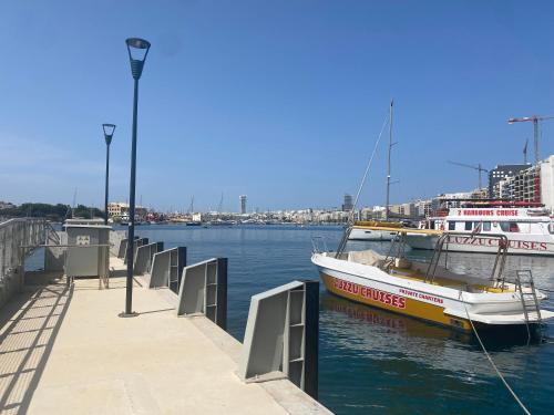 a boat is docked at a dock in the water at Sea Breeze Retreat - Comfort Apartments in the Heart of Sliema in Sliema