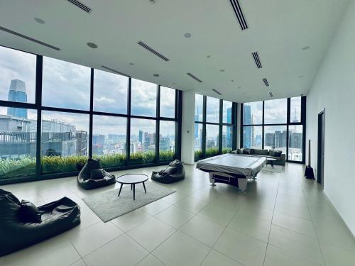 a large room with a pool table in a building with windows at Eaton Residences By Classic in Kuala Lumpur