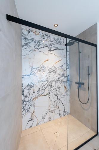a bathroom with a shower with a marble wall at Ardn-bnb Bike n Bed in La Roche-en-Ardenne