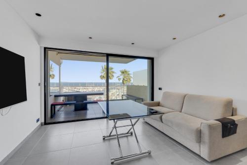 un salon avec un canapé et une table en verre dans l'établissement F2 Palm Beach - Pointe Croisette, à Cannes