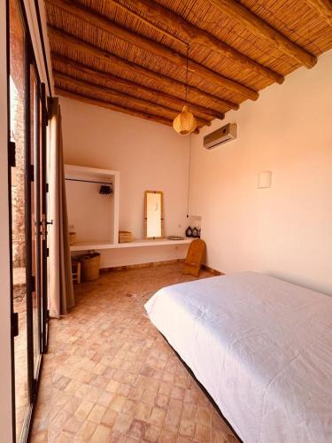 a bedroom with a large bed in a room at Modern oasis near Palmeraie - Dar Tal in Douar Oulad Ali