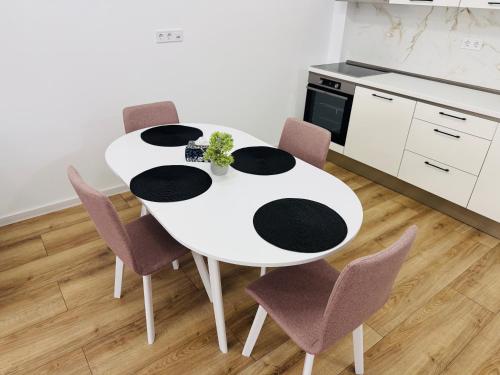a white table with purple chairs in a kitchen at Milan Luxury Apartaments XIII#Tudor in Corunca