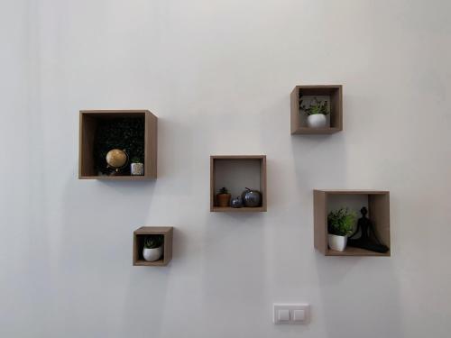 a white wall with three niches with plants in them at Apartmento Río Turia Caracol in Valencia