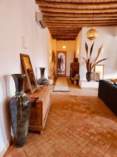 a large living room with vases on the floor at Modern oasis near Palmeraie - Dar Tal in Douar Oulad Ali