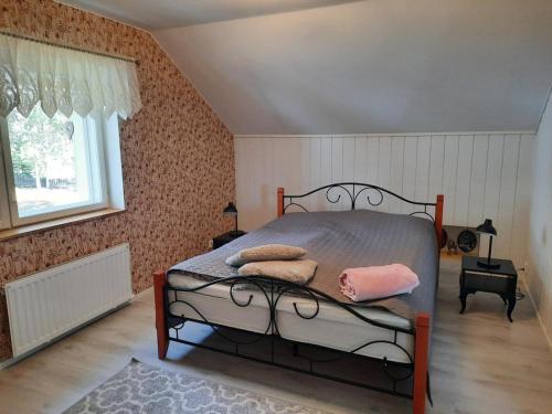 a bedroom with a bed with pink pillows on it at Villa Tarvas by Hilla Villas in Rovaniemi