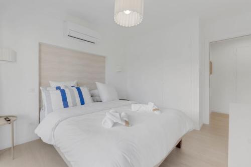 - une chambre blanche avec un lit blanc et des serviettes dans l'établissement 2-bedroom Royal Beach, à 2minutes de la plage, à Cannes