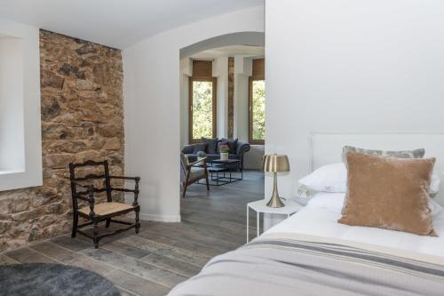 Majordoms - Castell de Villavecchia - 20 pax في سانت إلاري ساكالم: غرفة نوم بسرير وجدار حجري
