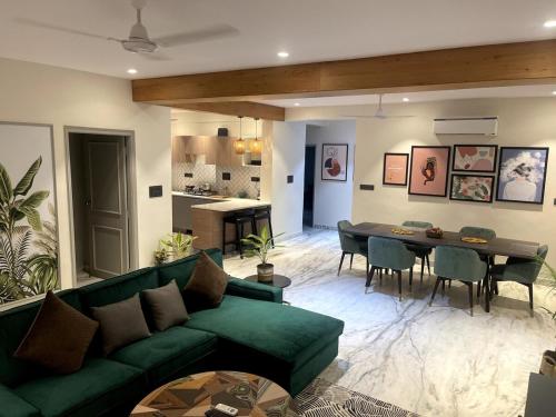 a living room with a green couch and a table at Casa Rio - Modern 3 BR near Fateh Sagar lake in Udaipur