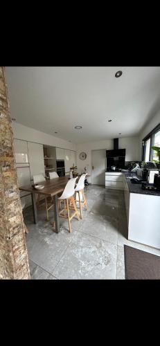 une cuisine avec une table et des chaises dans une pièce dans l'établissement Maison individuelle, au Mans