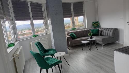 a living room with a couch and chairs and windows at MaFi apartment in Bitola