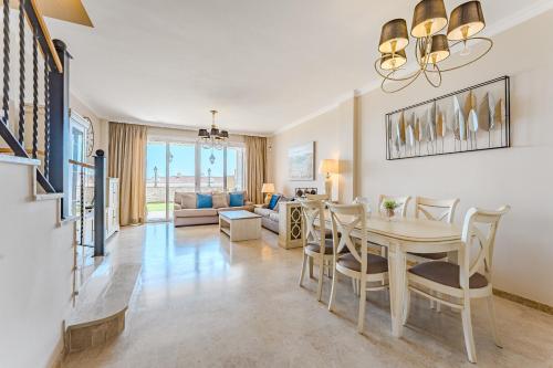 a dining room and living room with a table and chairs at Spacious Ocean View Family Townhouse in Puerto de Santiago