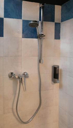a shower with a hose in a bathroom at InGarda Rooms in Cavalcaselle