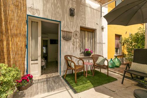 a patio with a table and chairs and an umbrella at InGarda Rooms in Cavalcaselle