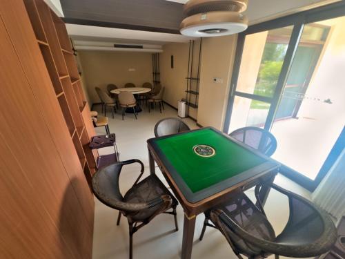 a table and chairs in a room with a table at Zhangjiajie Ldyllic Pondside Timber Lodge in Zhangjiajie