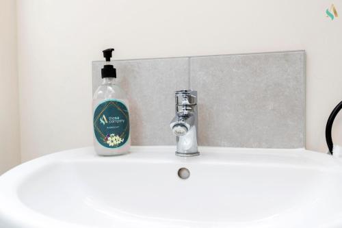 - une bouteille de savon assise sur un lavabo dans l'établissement Oakwood Lodge, à South Bank