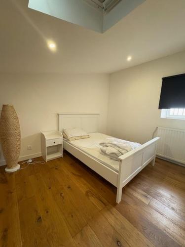 une chambre blanche avec un lit et une fenêtre dans l'établissement Elégant T3 aux Chartrons, à Bordeaux