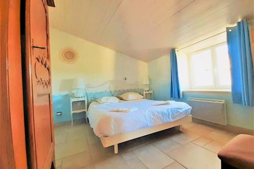 une chambre avec un lit et une fenêtre dans l'établissement Le Moulin aux Lavandes, à Redortiers