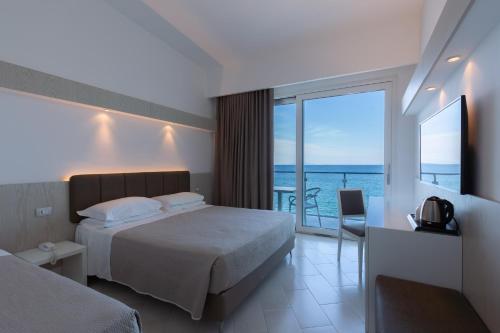 a bedroom with a bed and a view of the ocean at Hotel Giosue' a mare Sorrento in Meta