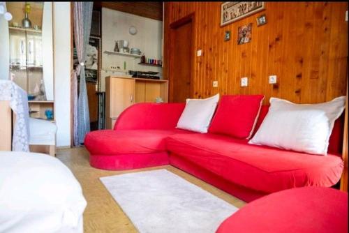 een rode bank met witte kussens in de woonkamer bij Apartma Maggie in Komiža